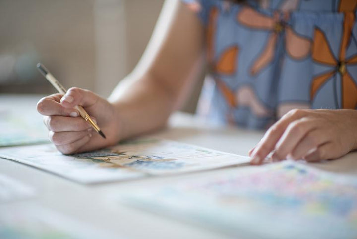 Artist painting a floral water color inspiration for our art bandanas