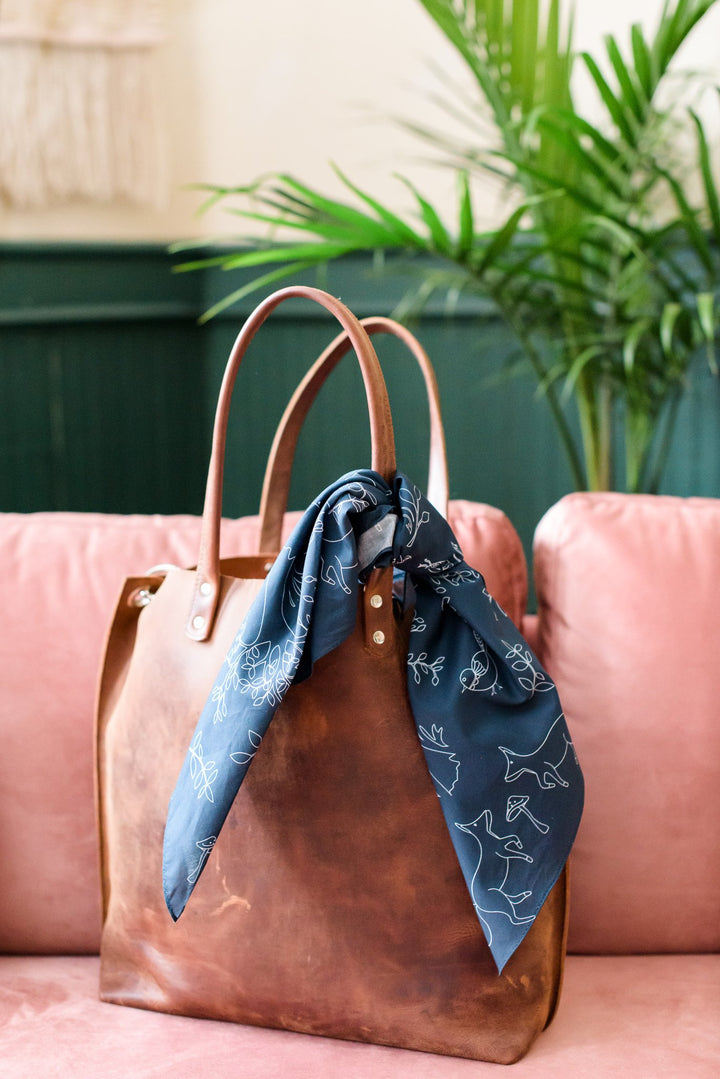 Navy blue animal print scarf bandana tied on leather handbag